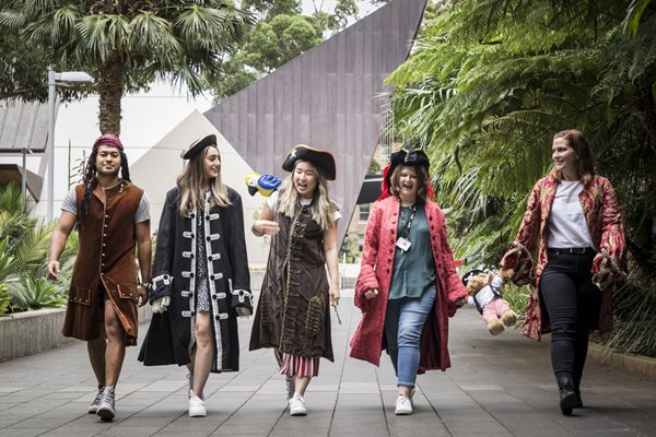 Dr. Upton and her crewmates dressed as pirates and walking in a row.